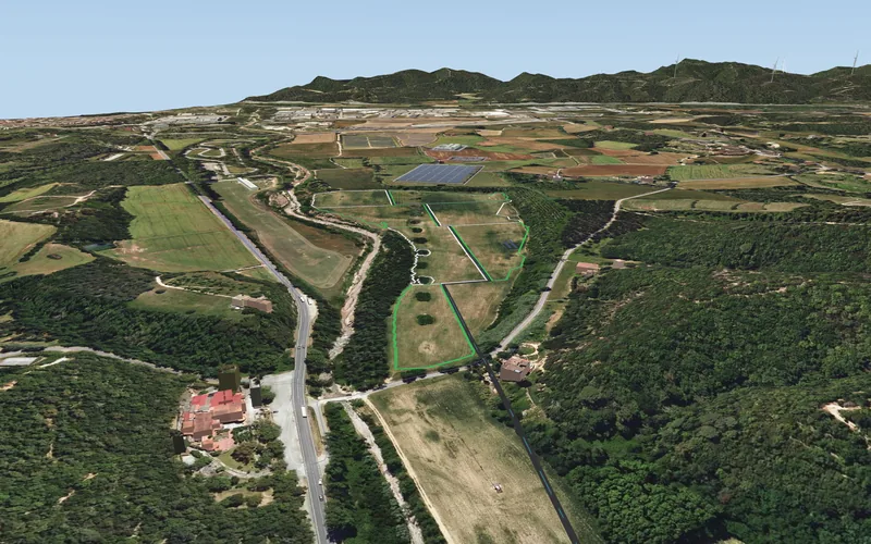The smart farm’s fields in the valley at Breda, outlined in their live colours, the solar plant and the Montseny beyond